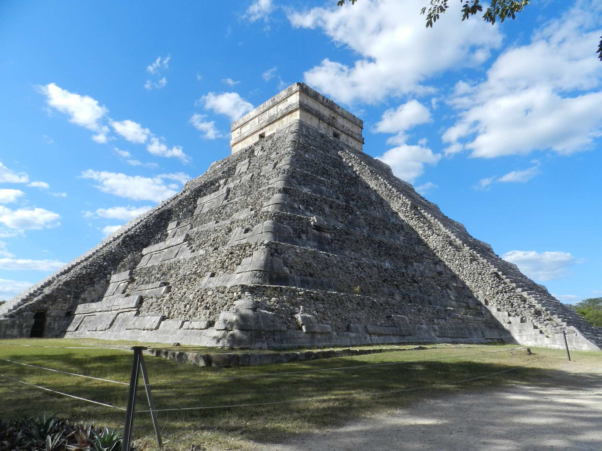 Chichen Itza pyramid El Castillo under blue sky on the Cancun minibus day trip